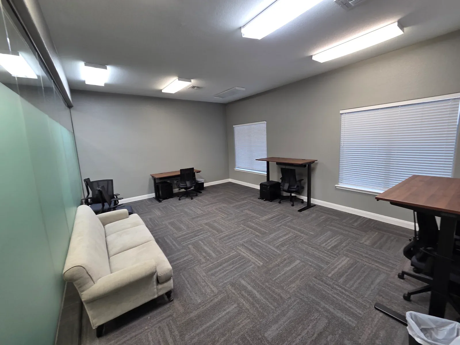 A large furnished private office at Corridor Collective in San Marcos, with desks, seating, and a window